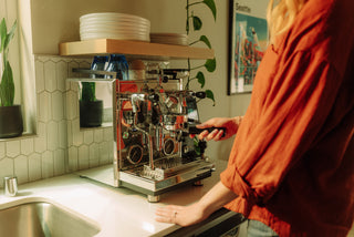 Profitec Drive espresso machine on a kitchen counter while a person in an orange top uses it