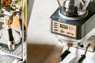 Baratza Sette 270Wi espresso grinder with a digital display beside a shiny espresso machine.