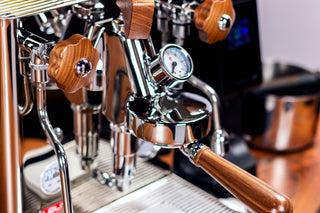 Close up of a Lelit Bianca V3 espresso machine with wood and chrome details and a pressure gauge