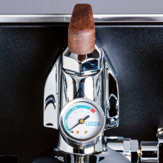 Close up of a LUCCA espresso machine lever with a brown wooden handle and a round pressure gauge