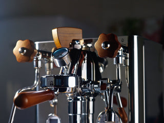 Close up of a Lelit espresso machine with wooden knobs and chrome levers