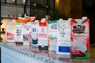 Row of assorted milk cartons on a granite kitchen counter
