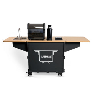 Front view of KlassyKarts mobile coffee cart with LUCCA espresso machine and grinder on a wood countertop and CLIVE COFFEE branding on the base