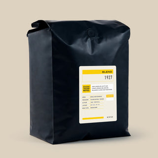 Panther Coffee 1927 Blend bag with a white label and yellow accent, photographed against a beige backdrop.