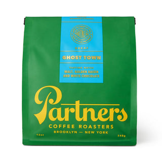 Green Partners Ghost Town Decaf coffee bag with a blue label and yellow branding.