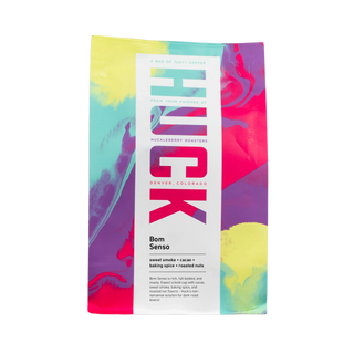 Bom Senso dark roast coffee bag with colorful abstract artwork and a white label.