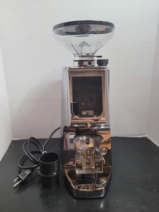Open box Eureka Atom W 75 espresso grinder with large clear hopper on top and copper chrome housing