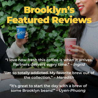 Two people hold blue and pink coffee cups outdoors with Brooklyn's Featured Reviews headline across the image.