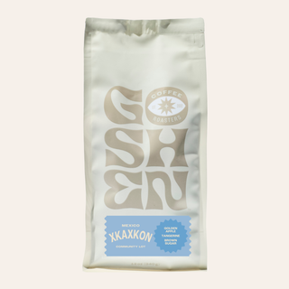 Partial view of a white XKAXKON coffee bag against a pale background