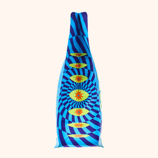 Blue and purple patterned coffee bag with yellow starburst motifs against a pale cream background.