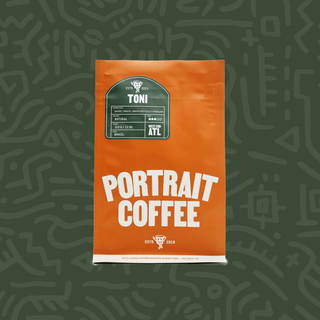 Orange Portrait Coffee bag labeled TONI with a green label on a muted green patterned backdrop