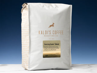 Dancing Goats Blend bag with white body and beige dotted side panel against a blue gradient backdrop