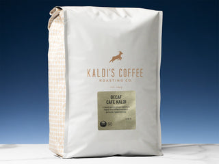 Kaldi's Decaf Cafe Kaldi coffee bag with white packaging and a patterned side panel against a blue backdrop