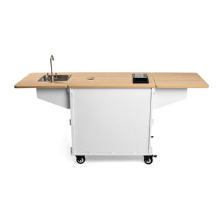 White mobile coffee cart with wooden countertop built in sink on the left and wheels for easy movement.
