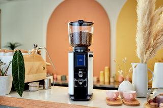 Anfim Luna espresso grinder with clear bean hopper in a bright cafe setup