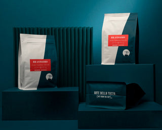 Bravissimo coffee bags on a teal display against a cafe style backdrop.