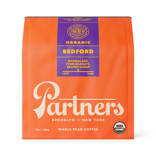 Bedford organic whole bean coffee in orange packaging with a purple label showing Bedford Organic