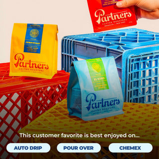 Colorful Partners Coffee Roasters bags Jumpstart and El Ramo displayed on stacked red yellow and blue crates.