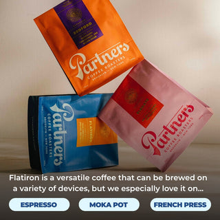 Three Partners Coffee bags in orange blue and pink showcase the Flatiron espresso blend