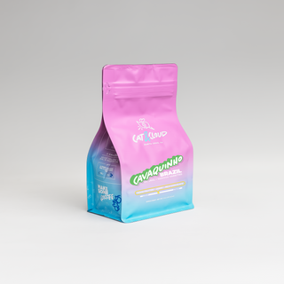 Pink Cat & Cloud Brazil Cavaquinho Natural coffee bag against a light gray backdrop