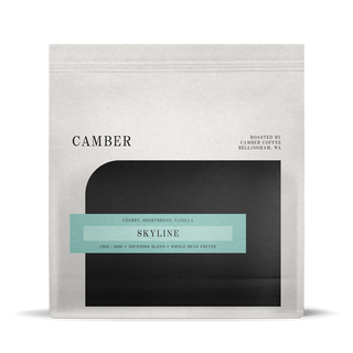 Camber Coffee Skyline espresso bag with teal label on a light bag over a black rounded inset.