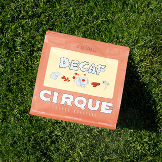 Cirque Coffee Roasters Decaf bag on grass with bold DECAF label