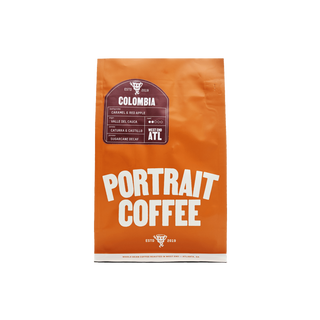 Portrait Coffee Colombia Sugarcane Decaf bag close up showing the orange packaging and label.