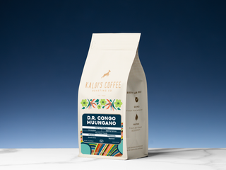 Kaldi's Congo Muungano coffee bag with blue label and colorful artwork, standing on a white surface.
