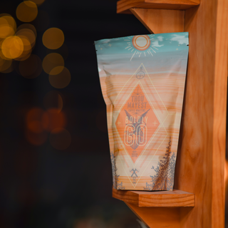 Boldly Go coffee bag on a wooden rack with warm orange bokeh lights in the background.