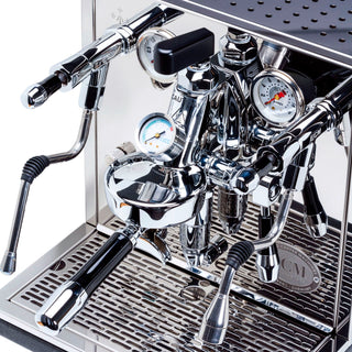 Upper front panel of ECM Synchronika espresso machine featuring a black lever and chrome fittings near a pressure gauge.