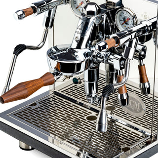 Close-up of ECM Synchronika II espresso machine with dual gauges, chrome lever, and wooden handles
