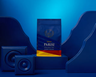 Parisi Hazelnut Almond Vanilla whole bean coffee bag on a blue and yellow backdrop