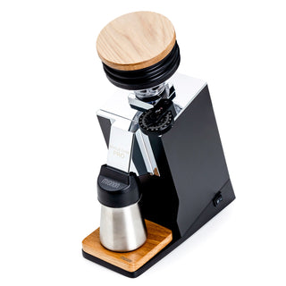 Eureka Oro Mignon Single Dose Pro espresso grinder shown from a side angle with wooden lid and chrome accents.