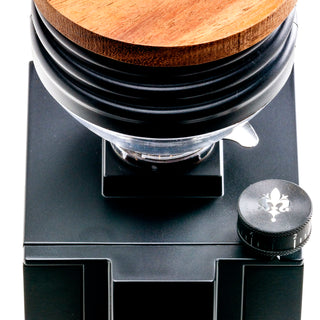 Close up top view of Eureka Mignon Zero 65 espresso grinder with wooden hopper lid and black body.