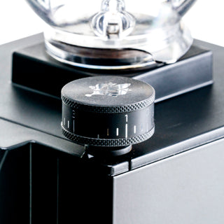 Front close up of Eureka Mignon Zero 65 grinder with portafilter mounted in the cradle.