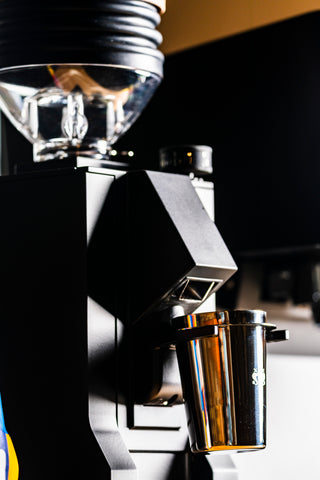 Close up of the Eureka Mignon Zero 65 grinder head with clear bean hopper and dial on black body