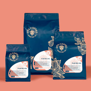 Flor del Sol Signature Blend coffee bags with citrus and caramel notes on a peach backdrop
