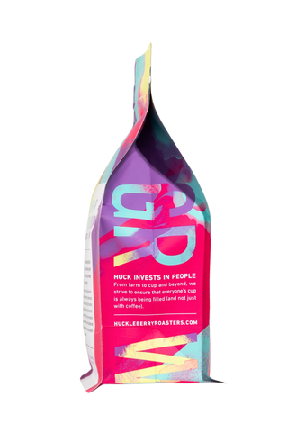 Side view of a vibrant Bom Senso Dark Roast coffee bag with abstract artwork