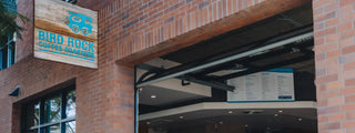 Bird Rock Coffee Roasters storefront on brick building with a blue sign