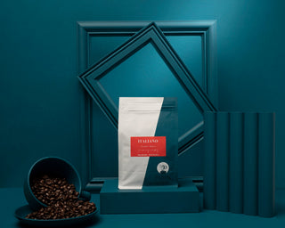 Italiano coffee bags arranged among teal geometric frames with a bowl of roasted beans in foreground