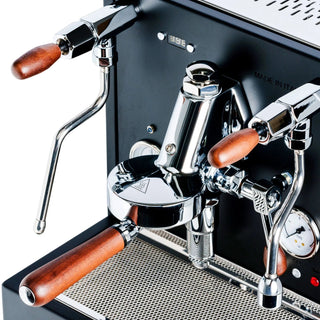 Front view of a chrome espresso machine featuring a two tier E61 group head and wooden-handled portafilters
