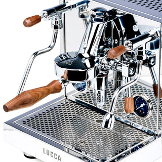Close up of the LUCCA M58 Sunto espresso machine front showing chrome levers with walnut wood handles and a polished stainless body