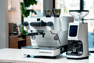 La Marzocco Linea Mini espresso machine with dual boiler on a kitchen counter and two cups on top.