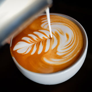 Latte art swirl on a cup with orange crema captured in a close up shot