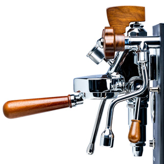 Lelit Walnut Bottomless Portafilter with a polished walnut handle attached to a chrome espresso machine head