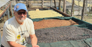 Sergio Ticas at Los Planes coffee farm beside drying parchment on raised beds in Chalatenango El Salvador