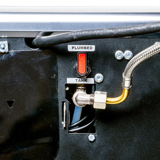 Plumbed connection area on the machine with a red control lever, braided hose attached to a brass fitting and mounting hardware.