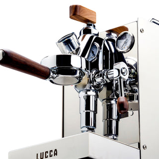 Close up of LUCCA Solo espresso machine chrome body with E61 group head, wooden knob, and gauge.