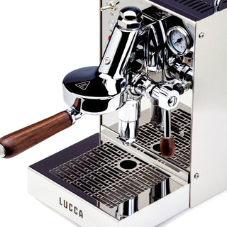 Angled view of LUCCA Solo espresso machine showing chrome body and wooden portafilter
