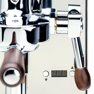 Close-up of LUCCA Solo front panel with a digital display, control arrows, and a wooden portafilter handle.